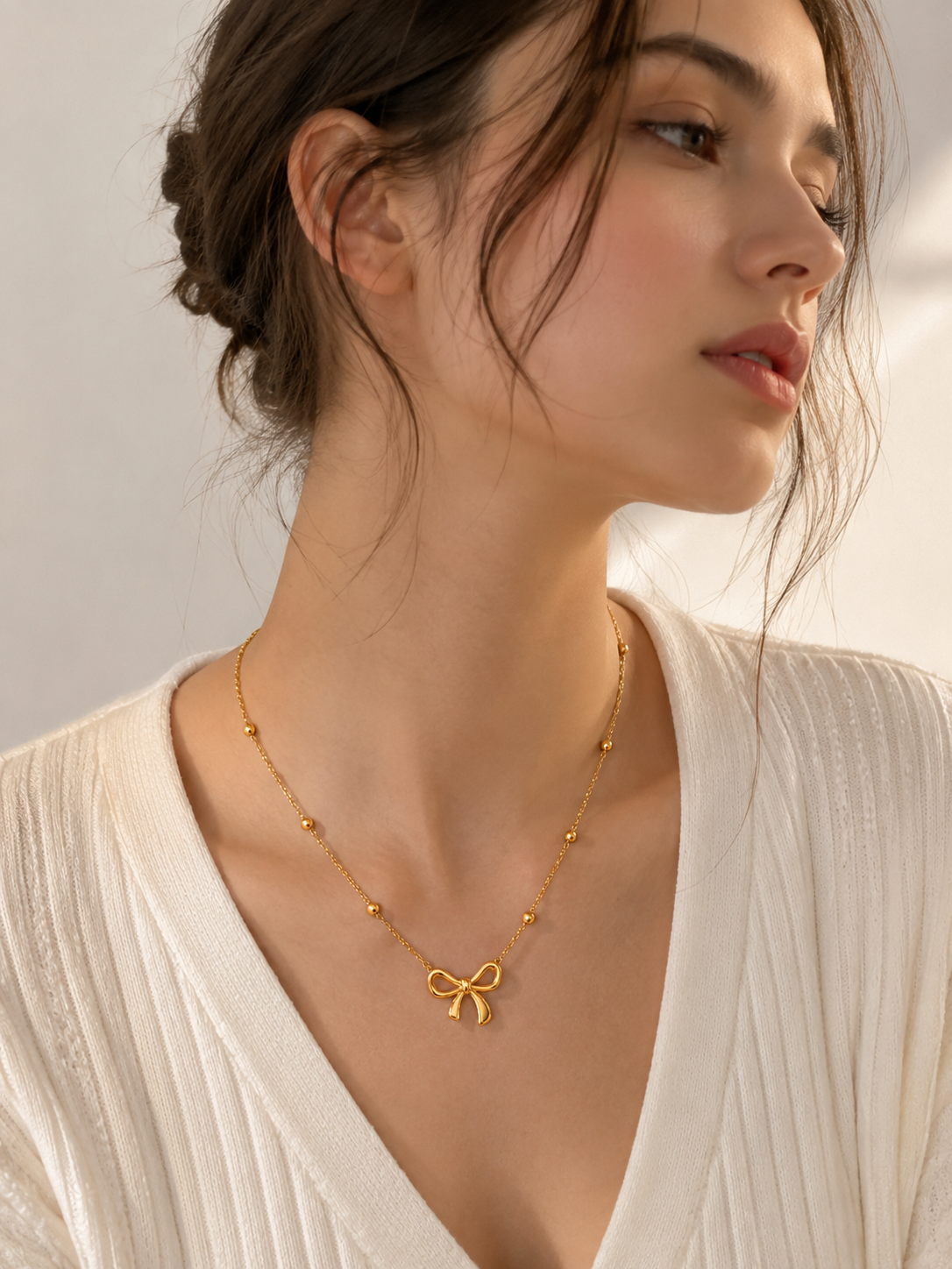 Woman wearing a gold bow knot necklace with a bow pendant for simple everyday outfit