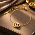 Gold bracelet with interlocking rings on a brown surface