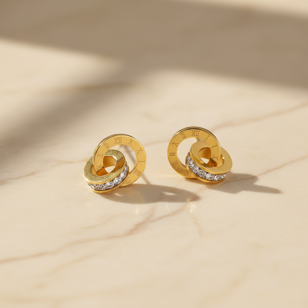 Gold earrings with interlocking rings on a brown surface