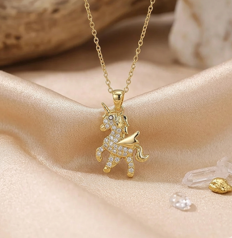 Gold unicorn necklace on a beige fabric background