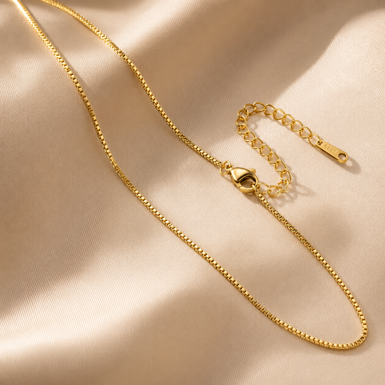 Gold chain necklace on a beige fabric background everyday unisex chain