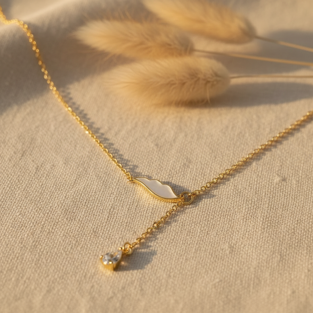 Gold necklace with a clear pendant on a white plate