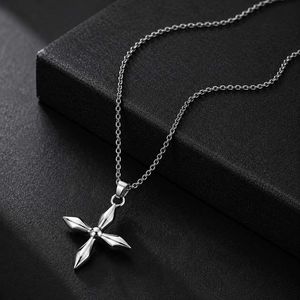 Silver cross pendant necklace on a black surface