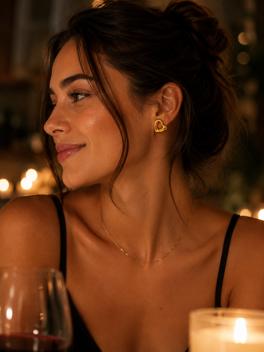 Woman wearing a heart,shaped earring in a warm, dimly lit setting date night