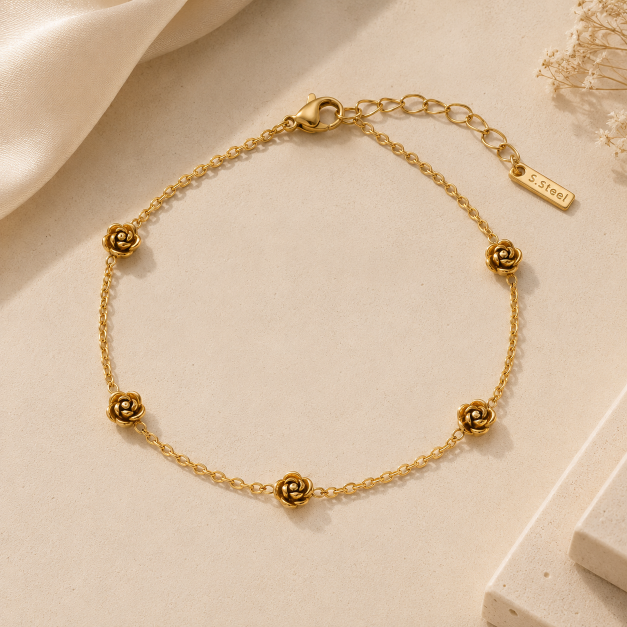 Gold bracelet with floral designs on a beige background