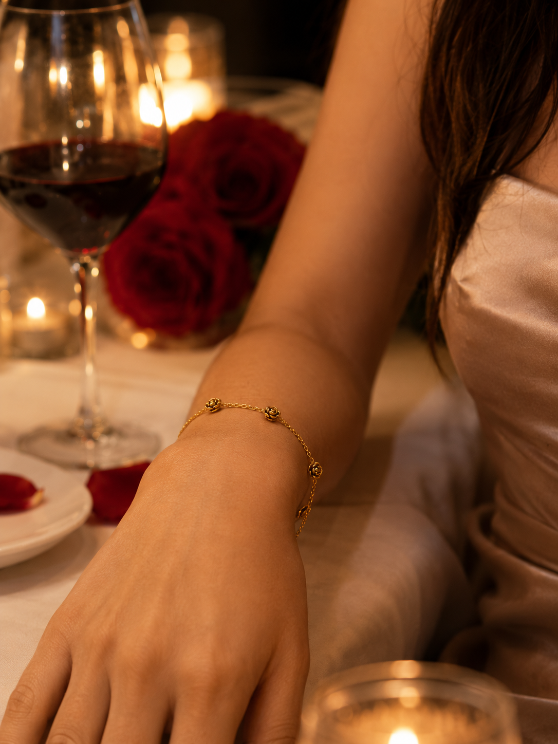 Person at a romantic dinner setting with a glass of wine, candles, and red roses.